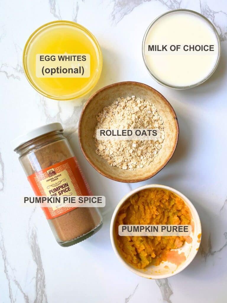 Main pumpkin oatmeal ingredients layered on a white surface