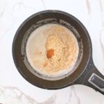 Rolled oats and pumpkin spice mix added to simmering milk