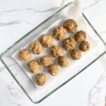 Lentil meatballs arranged in baking tray covered with parchment paper, ready for baking