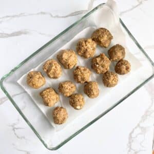 Lentil meatballs arranged in baking tray covered with parchment paper, ready for baking