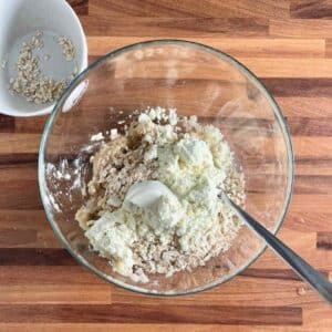 Protein powder and rolled oats added to mashed bananas, before mixing