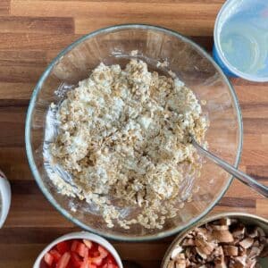 Mixing rolled oats and cottage cheese in a bowl, before adding vegetables